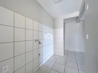 Banheiro com revestimento cerâmico branco nas paredes.