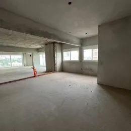 Foto de um espaço interno amplo e vazio com teto exposto.