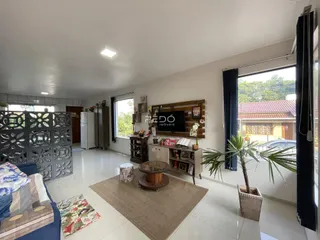 Sala de estar iluminada com piso de cerâmica e vista para o exterior.