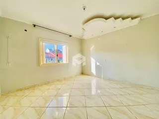 Vista interna de um ambiente com piso de cerâmica clara e paredes brancas.