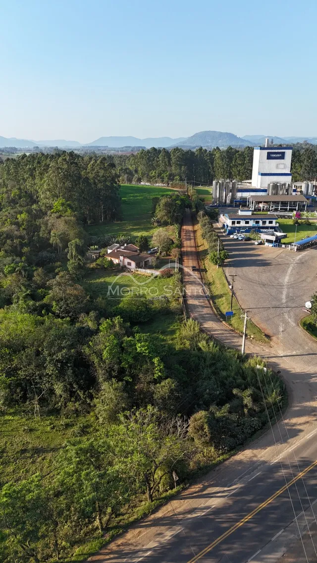 Vista aérea de uma área rural com vegetação densa e estradas.