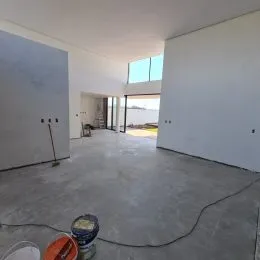 Foto de um ambiente interno amplo e vazio com piso de concreto.