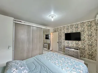 Quarto com cabeceira e guarda-roupa em um apartamento no Brasil.
