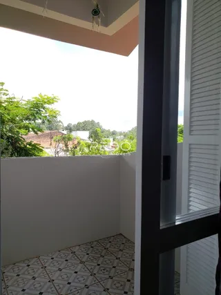 Vista de um interior com piso de cerâmica e vista para a vegetação externa.