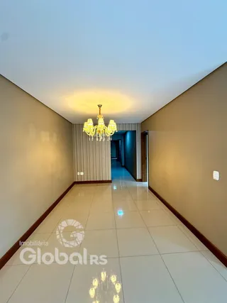 Corredor interno de uma residência com piso de cerâmica e teto branco.