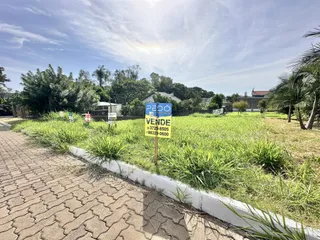 Vista da fachada de uma propriedade em Lajeado, Brasil, com área gramada e vegetação.