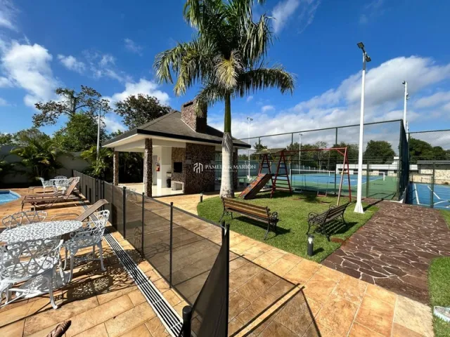 Área externa com deck de madeira e gramado em uma propriedade.
