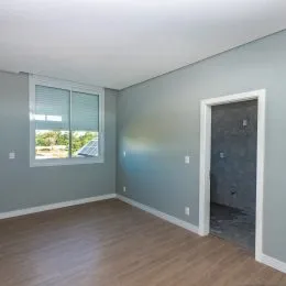 Foto de um cômodo interno com paredes cinzas e piso de madeira.