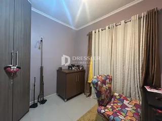 Quarto com paredes cinza e cortinas claras.