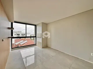 Interior de uma sala com grande janela de vista para o telhado.