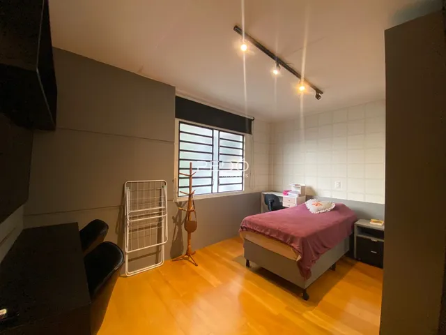 Quarto com piso de madeira e janela no interior de uma residência.
