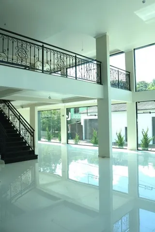 Vista interna de um espaço com varanda e piso reflexivo.