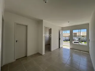 Hall de entrada com piso de cerâmica e paredes brancas em um imóvel no Brasil.