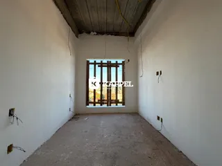 Interior de um cômodo com paredes brancas e piso de concreto aparente.