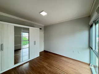 Ambiente interno com piso de madeira e armários embutidos.