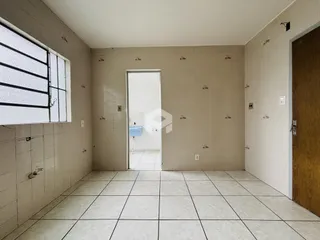 Interior de uma sala com piso de cerâmica e janela.