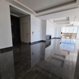 Hall de entrada com piso de mármore polido e paredes brancas.
