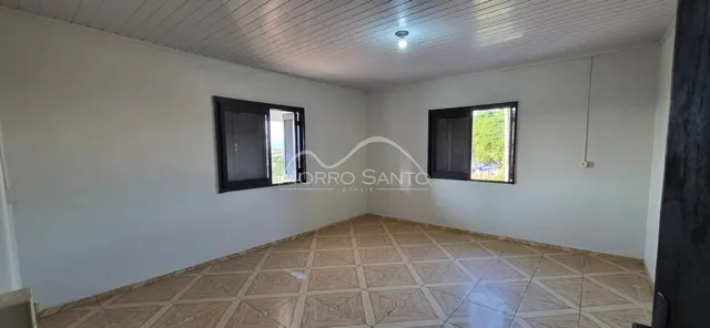 Sala de estar com piso de cerâmica clara e paredes brancas.