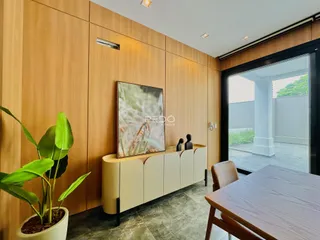 Sala de estar com painel de madeira e porta de vidro que dá para o exterior.