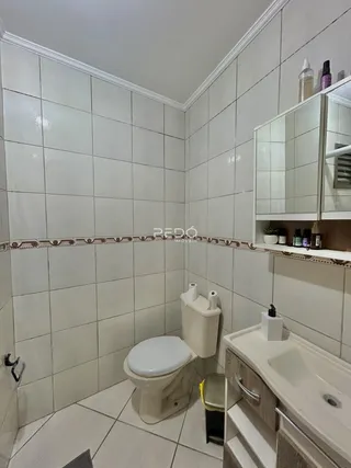 Foto de um banheiro com revestimento cerâmico nas paredes e piso.