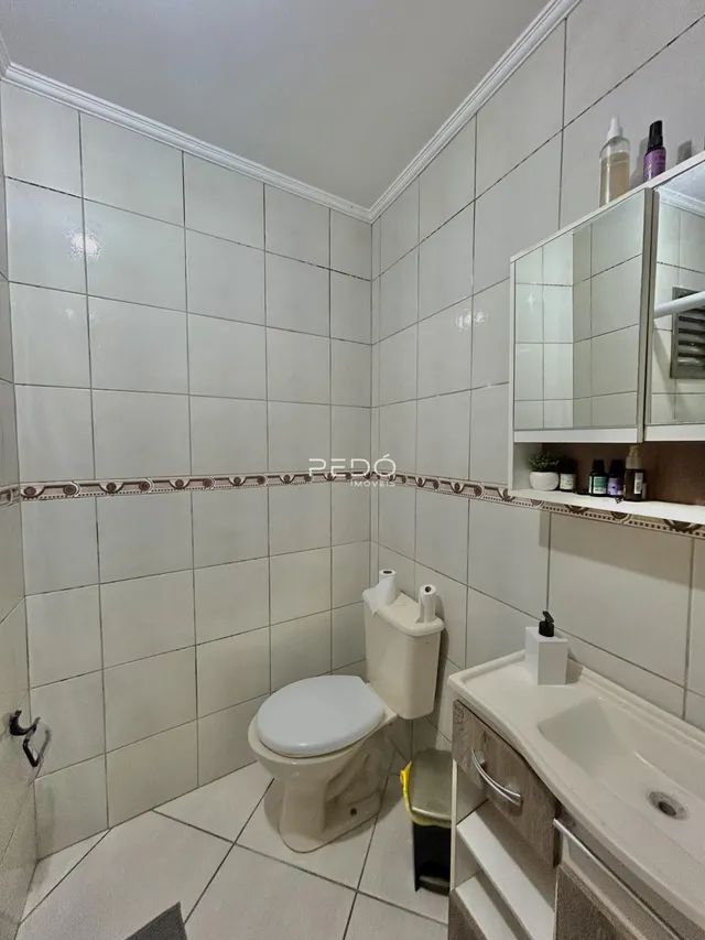 Foto de um banheiro com revestimento cerâmico nas paredes e piso.