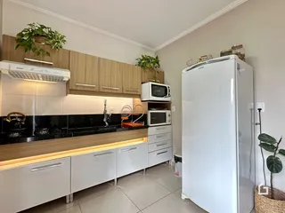 Foto de uma cozinha moderna com armários de madeira e bancadas escuras.