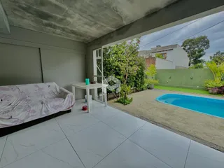 Quarto com acesso a uma área externa com piscina e jardim.