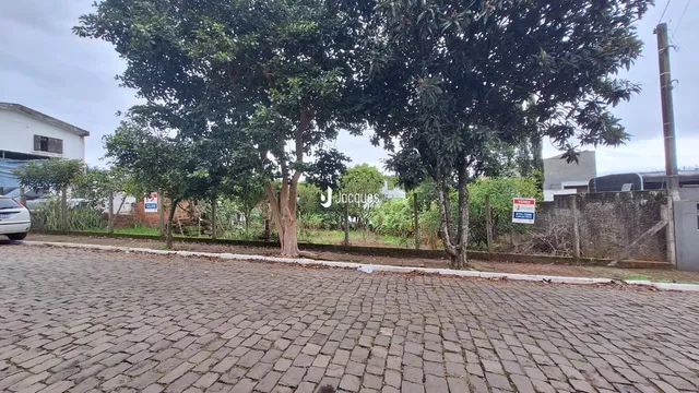 A fachada da propriedade em Lajeado, Brasil, mostra uma área pavimentada com árvores.