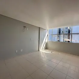 Ambiente interno com piso de cerâmica e grande abertura para o exterior.