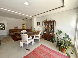 Sala de estar com sofá, mesa de jantar e estante de madeira em um imóvel no Brasil.