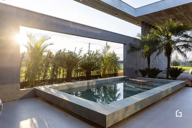 Piscina externa com vista para a vegetação tropical.