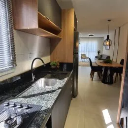 Foto de uma cozinha com bancadas escuras e armários de madeira.