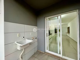 Vista de uma pia e parede revestida em um imóvel no Brasil.