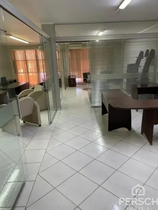 Hall de entrada com piso de cerâmica e portas de vidro.