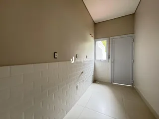 Corredor interno com piso cerâmico e paredes claras.
