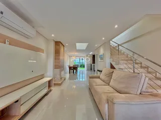 Ambiente interno moderno com piso claro e sofá na sala de um imóvel em Lajeado.