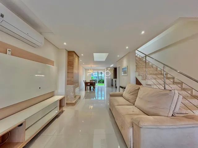 Ambiente interno moderno com piso claro e sofá na sala de um imóvel em Lajeado.