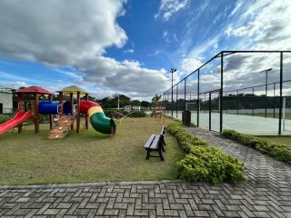 Uma área externa com playground e gramado é visível no imóvel.