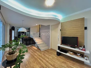 Sala de estar com piso de madeira e parede de destaque.