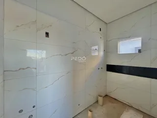 Parede interna com revestimento de mármore branco e detalhes em preto.