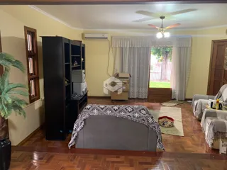 Sala de estar com piso de madeira e janela grande.