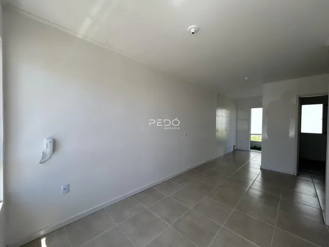 Hall de entrada com piso de cerâmica e paredes brancas.