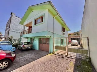 Fachada de uma casa em Lajeado, Brasil com portão de madeira.