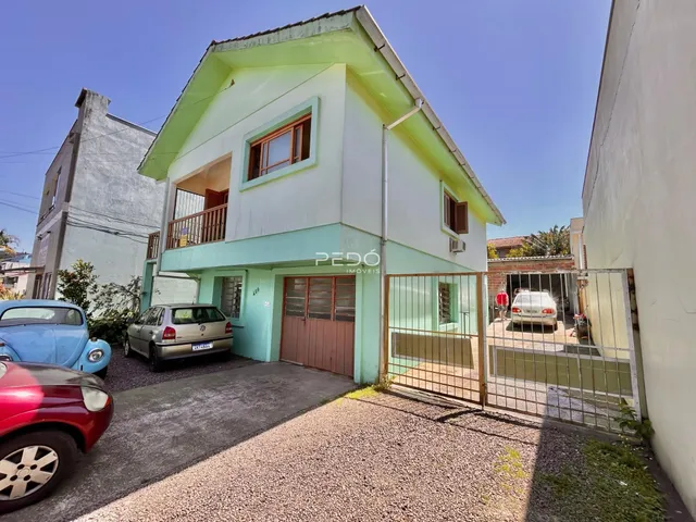 Fachada de uma casa em Lajeado, Brasil com portão de madeira.