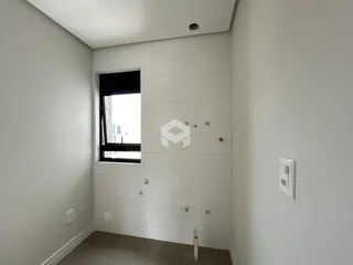 Hall de entrada com paredes brancas e piso claro.