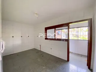 Foto de um cômodo interno com paredes brancas e piso cinza.