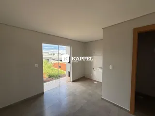Uma sala de estar com piso de cerâmica e porta de vidro que dá acesso ao exterior.