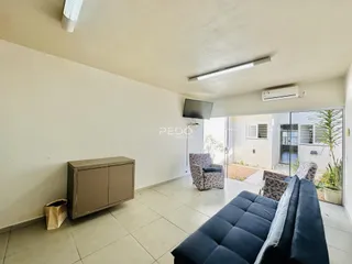 Sala de estar com piso de cerâmica e porta de vidro abrindo para o exterior.