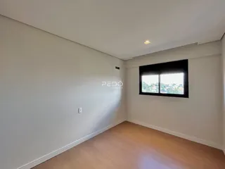 Foto de um ambiente interno com paredes brancas e piso de madeira clara.