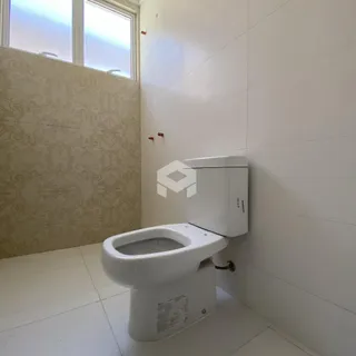 Banheiro com piso de cerâmica e paredes revestidas.